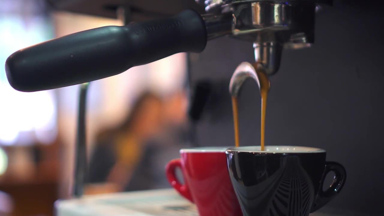 Espresso cayendo en una taza roja