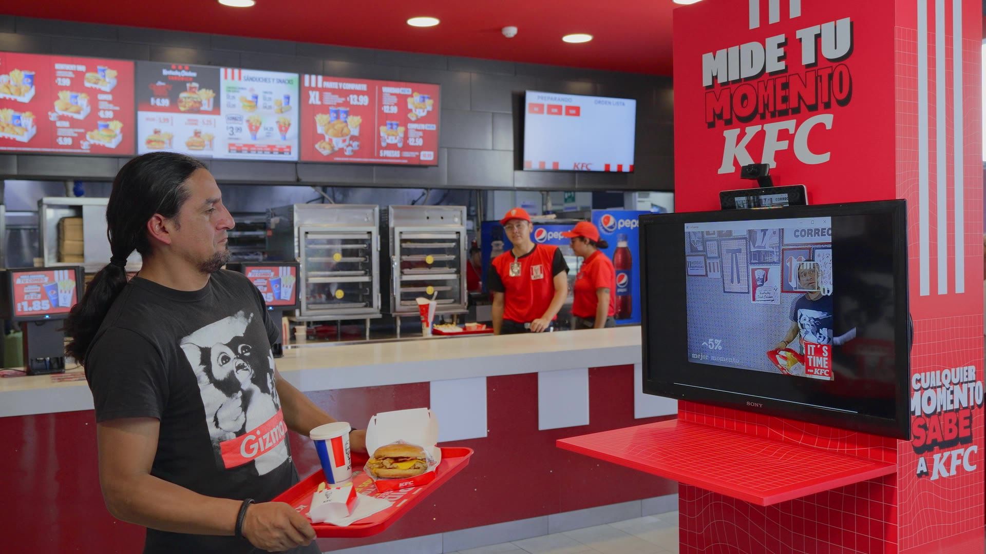 La acción: un cliente frente al kiosco Mide tu momento KFC