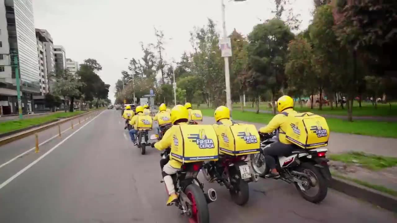 Repartidores en moto con chaquetas amarillas recorriendo la ciudad